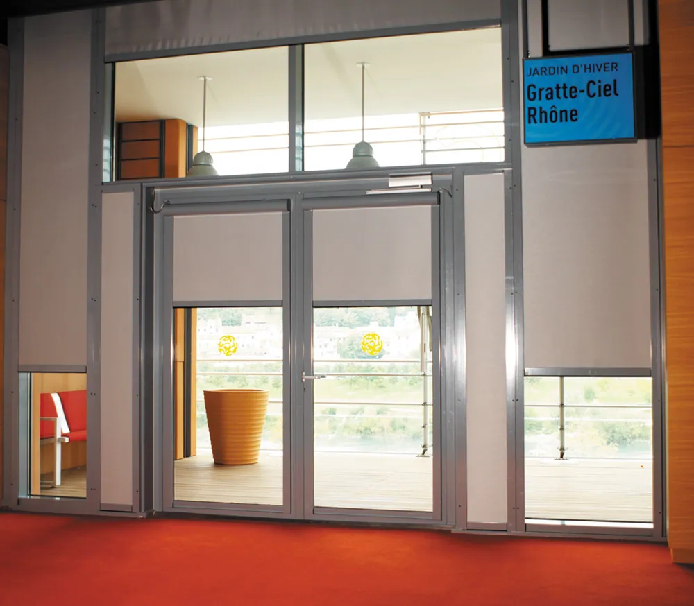Entrée vitrée avec panneau bleu "SERVICE CLIENTÈLE" dans un bâtiment moderne.