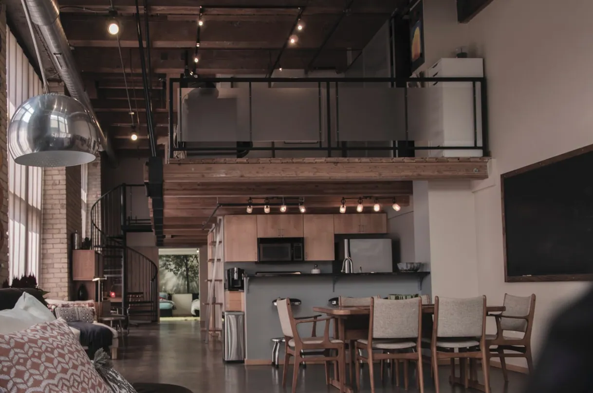 Loft moderne spacieux, cuisine ouverte, salle à manger, mezzanine et poutres apparentes.
