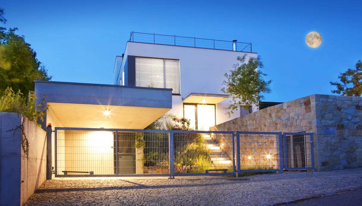 Maison moderne éclairée la nuit sous la pleine lune, architecture élégante.