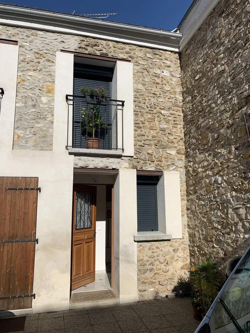 Maison traditionnelle en pierre, porte en bois, volets et balcon fer.