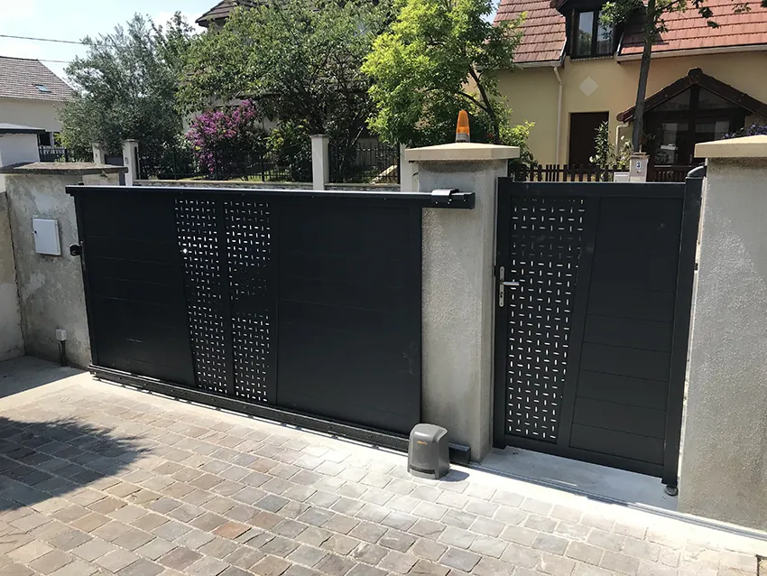 Portail coulissant et portillon modernes gris foncés pour propriété.