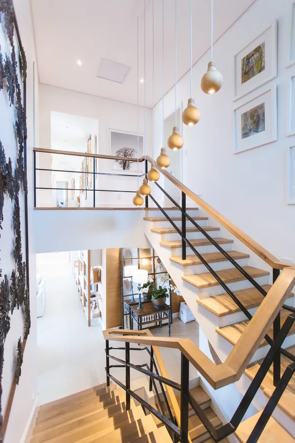 Escalier intérieur moderne en bois et métal noir dans maison lumineuse.