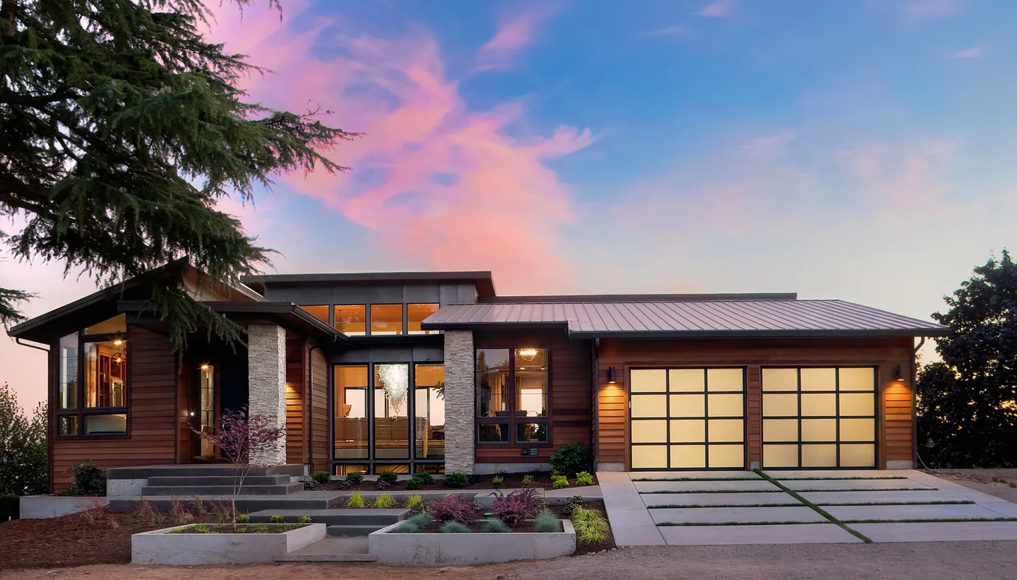 Superbe maison moderne en bois avec garage vitré sous coucher de soleil.