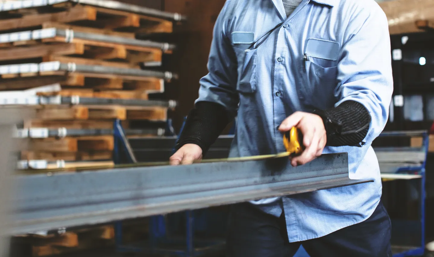 Menuisier mesurant un profilé en aluminium